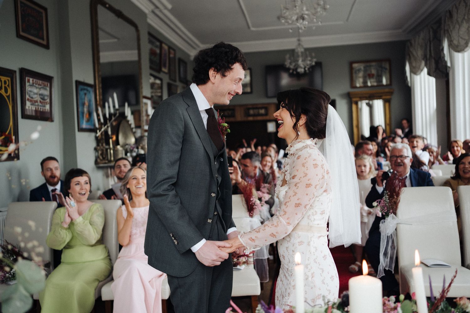 Bride and groom laughing during their wedding ceremony in the Haven Hotel wedding venue . Pink vintage wedding dress