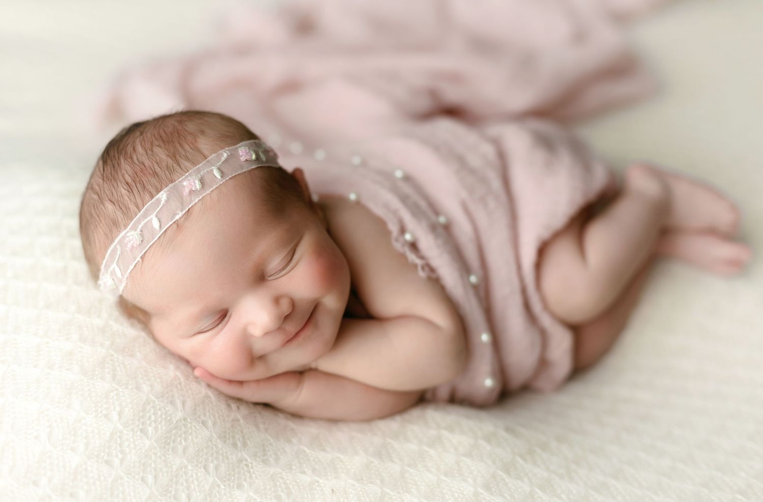 A newborn baby with a smile in a pink wrap. Greenville SC newborn photographer, Easley, SC newborn photographer, Upstate SC newborn