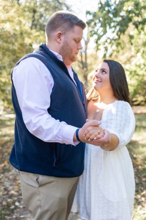 A couple holds hands and shares a loving moment during their engagement photos.