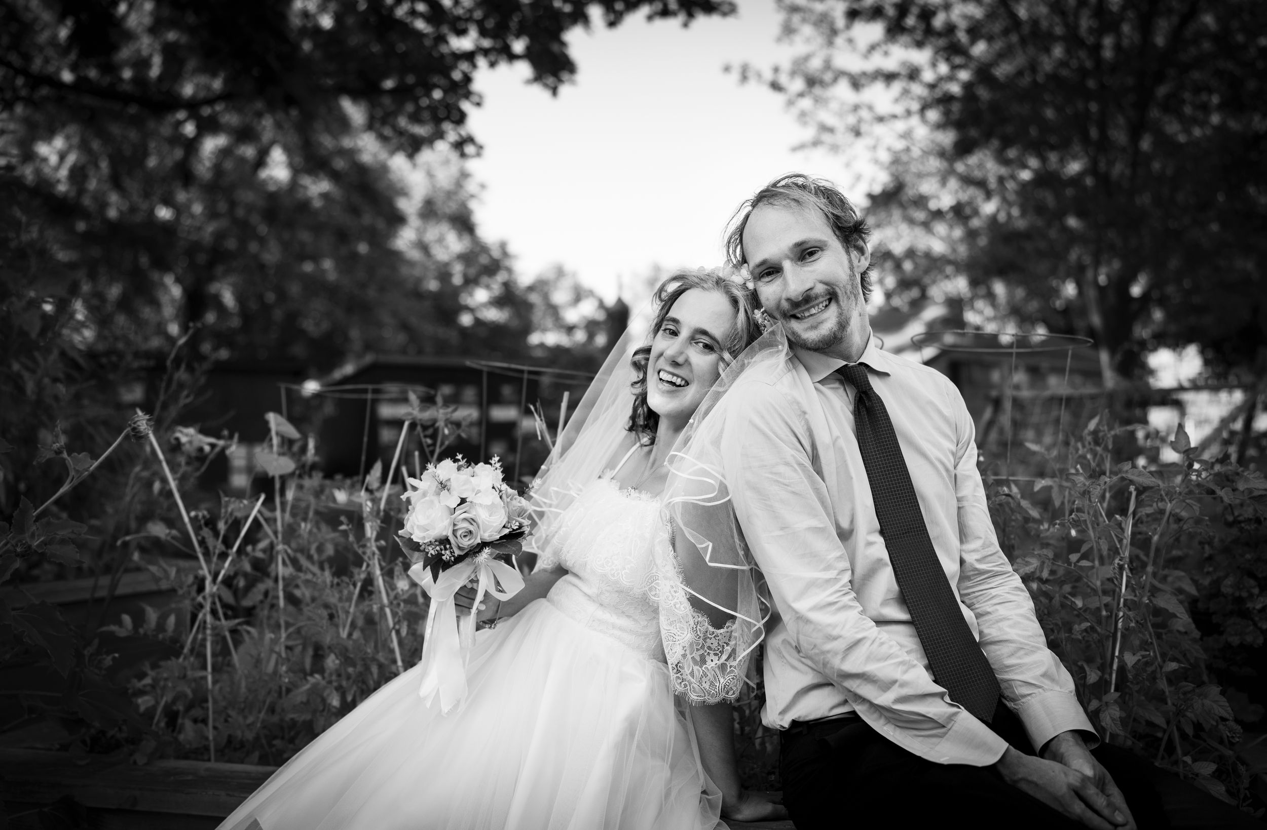 Bride and groom sitting together smiling posing.