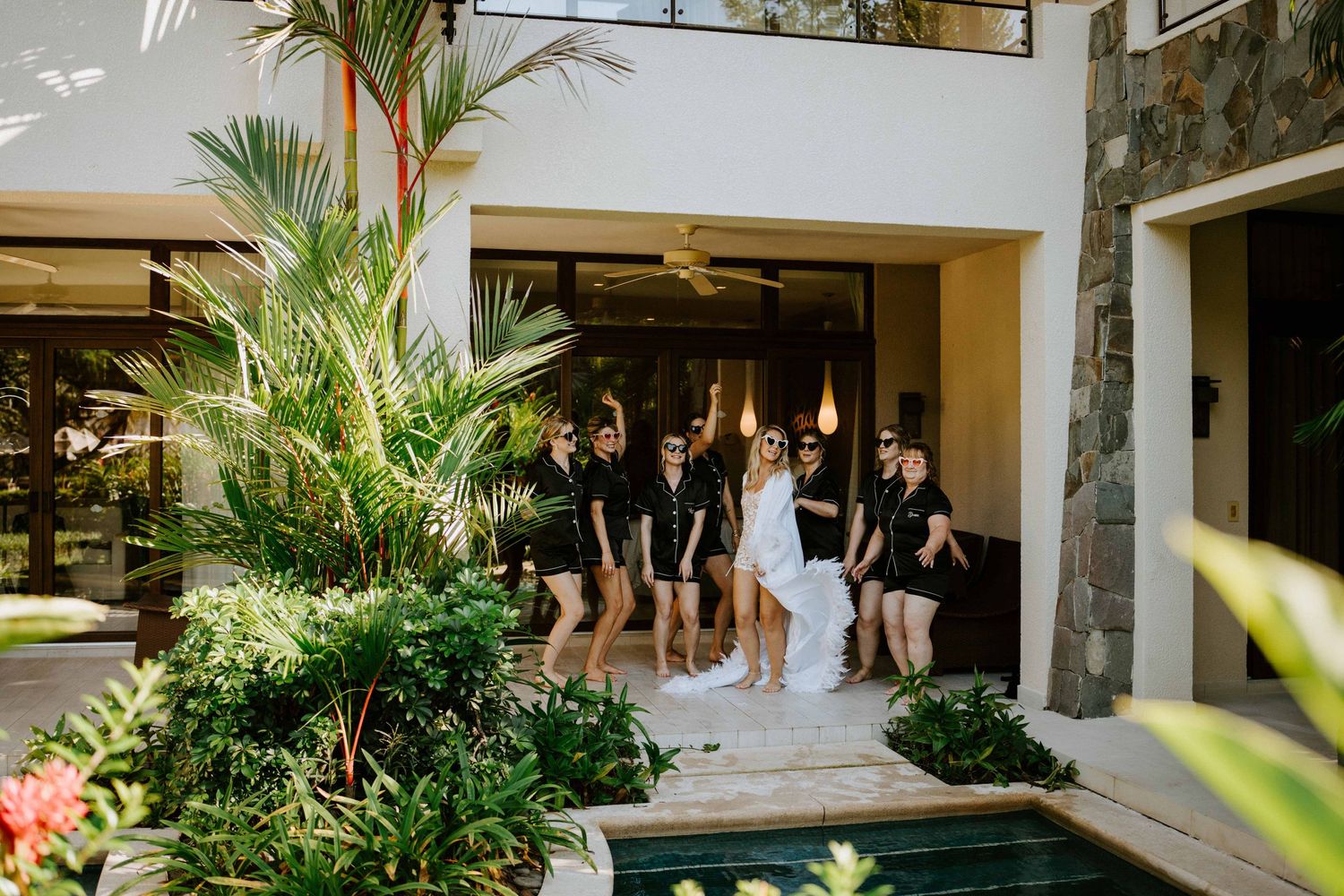 Candid shot capturing the laughter and joy of a bridal party celebration on the tropic shores of Dreams Las Mareas, Cost