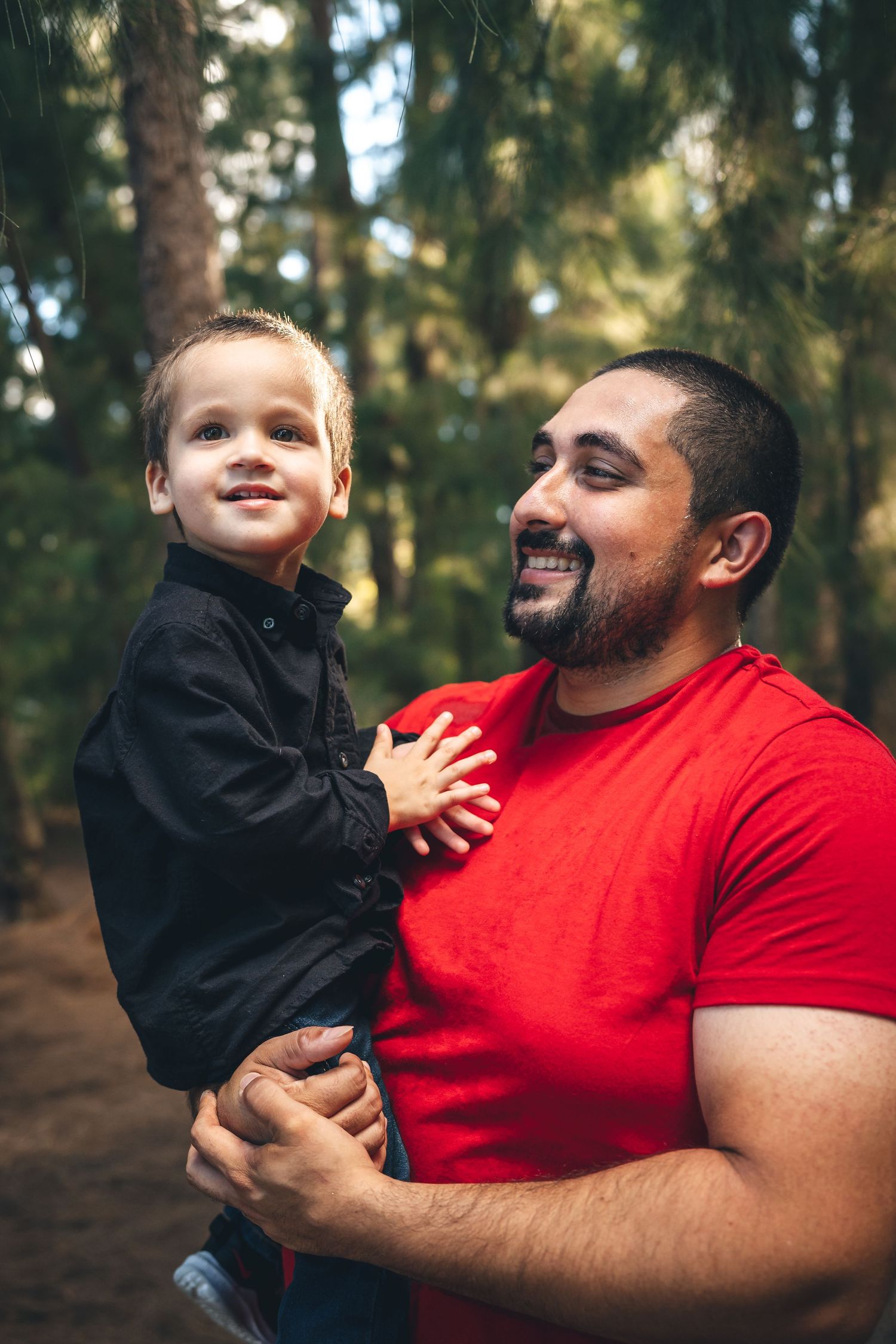 Parent and child share joyful moment together in forest setting.