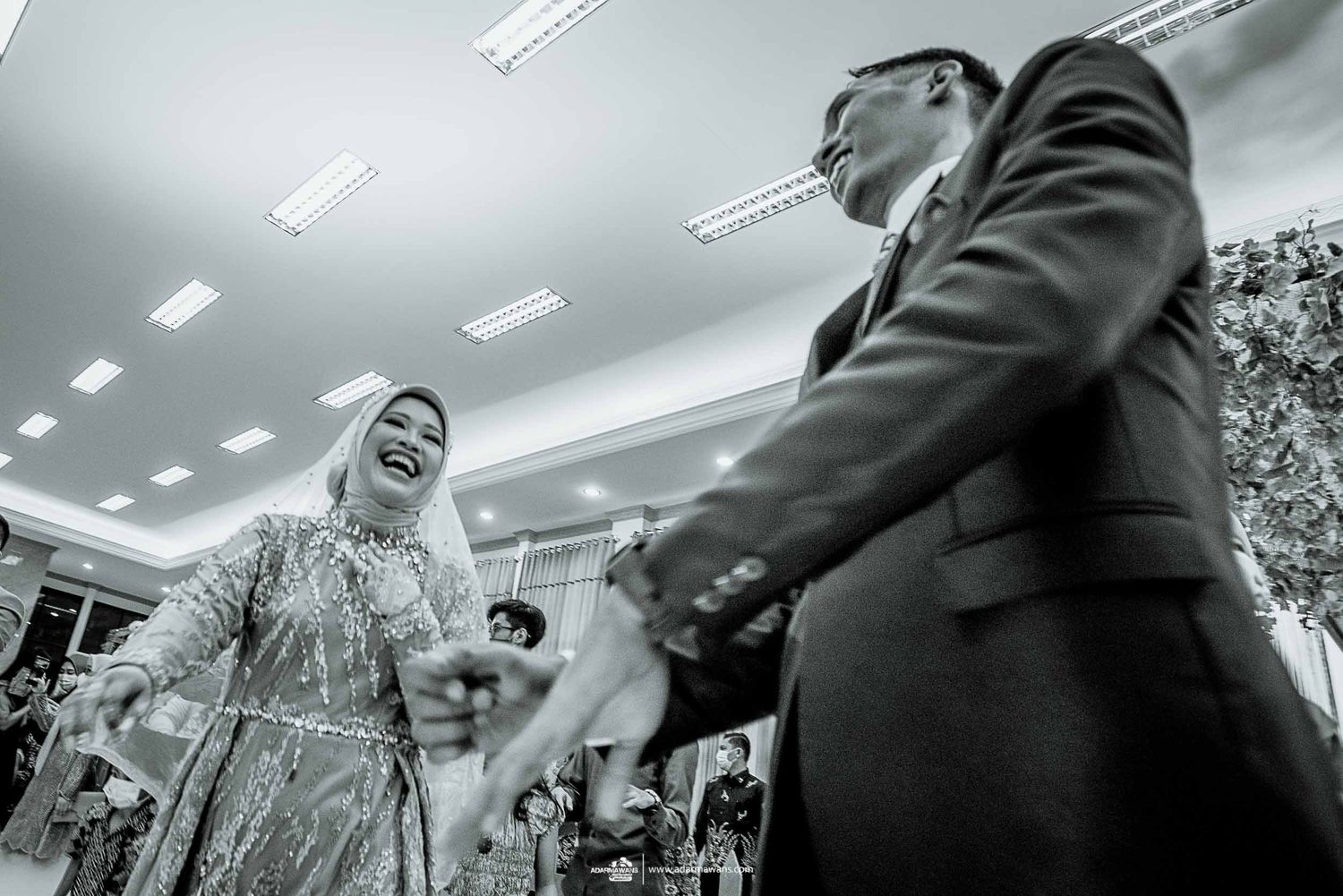 Candid black and white shot of celebratory dancing at a wedding reception.
