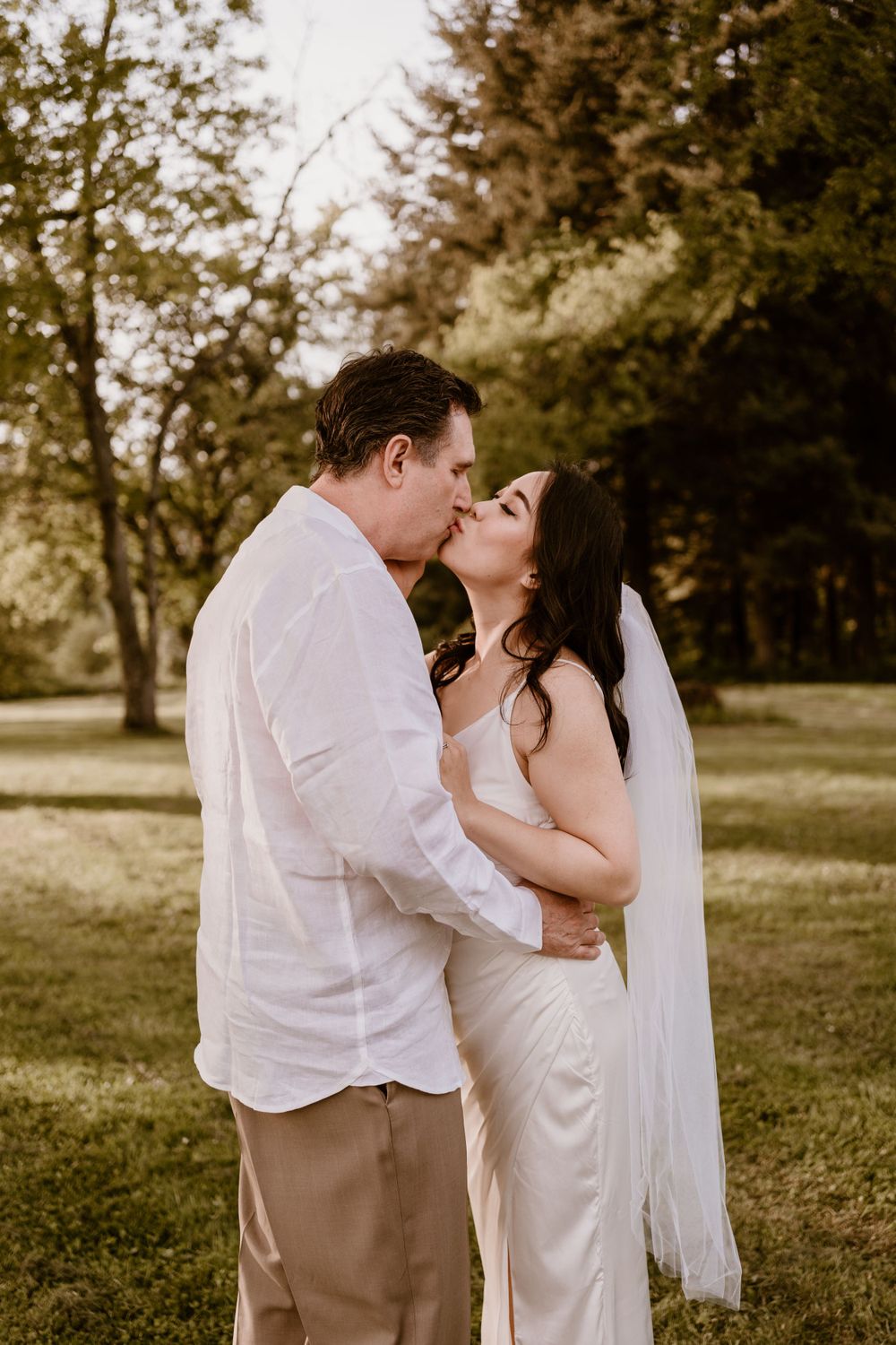 A romantic moment captured in a garden setting with soft lighting.