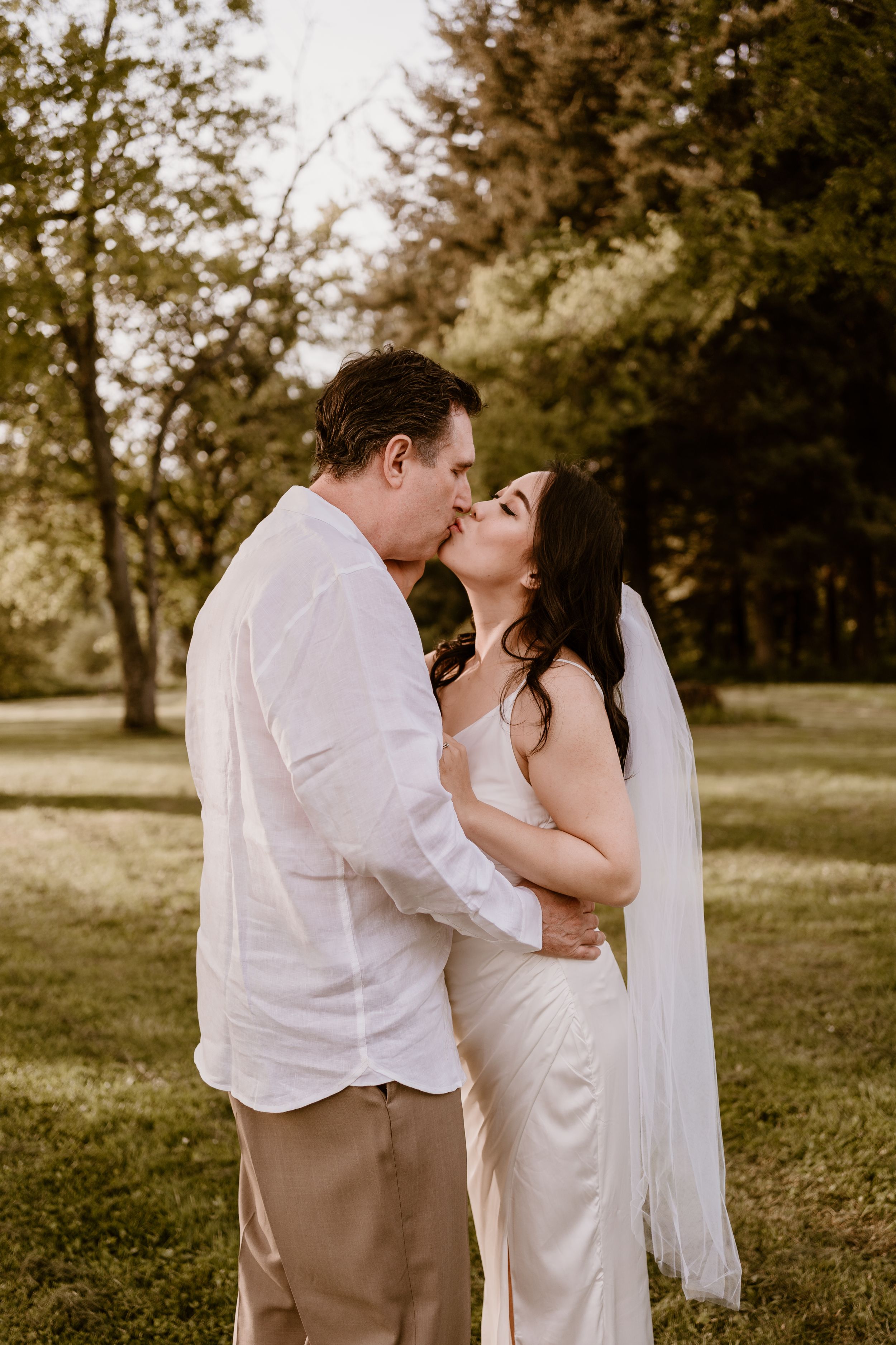 A romantic moment captured in a garden setting with soft lighting.