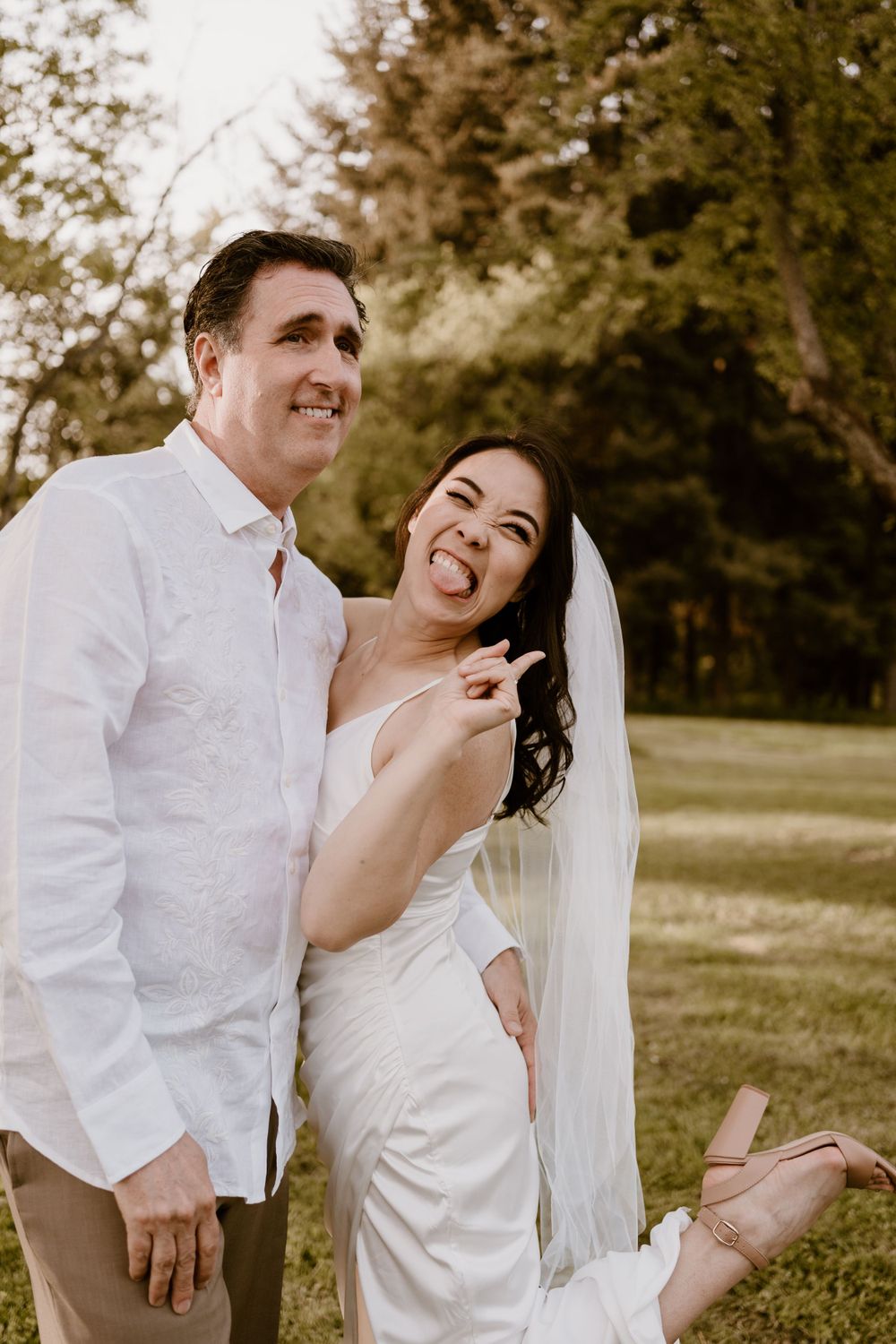 Joyful laughter shared between two people in white clothing outdoors.