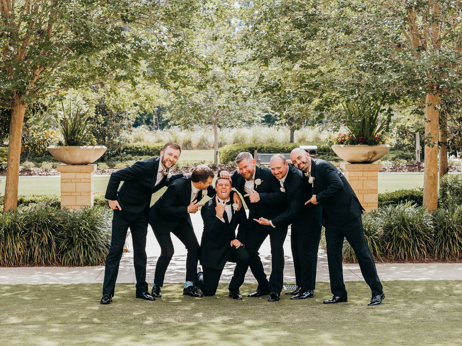 Groom and his groomsmen celebrate before wedding on lawn at Four Seasons in Kissimmee.