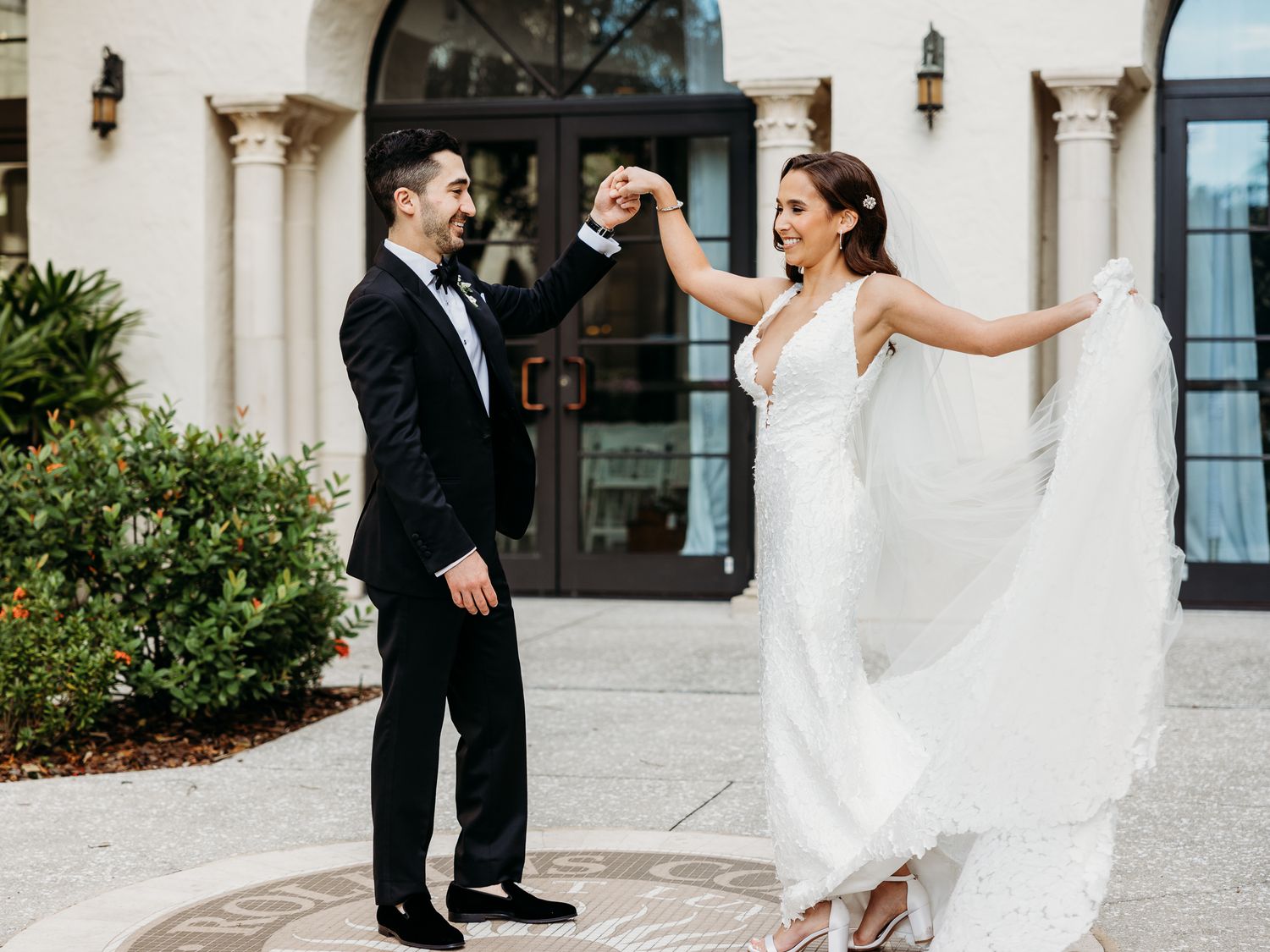 Bride shows off dress to groom at first look in Alfond Inn in Winter Park Florida.