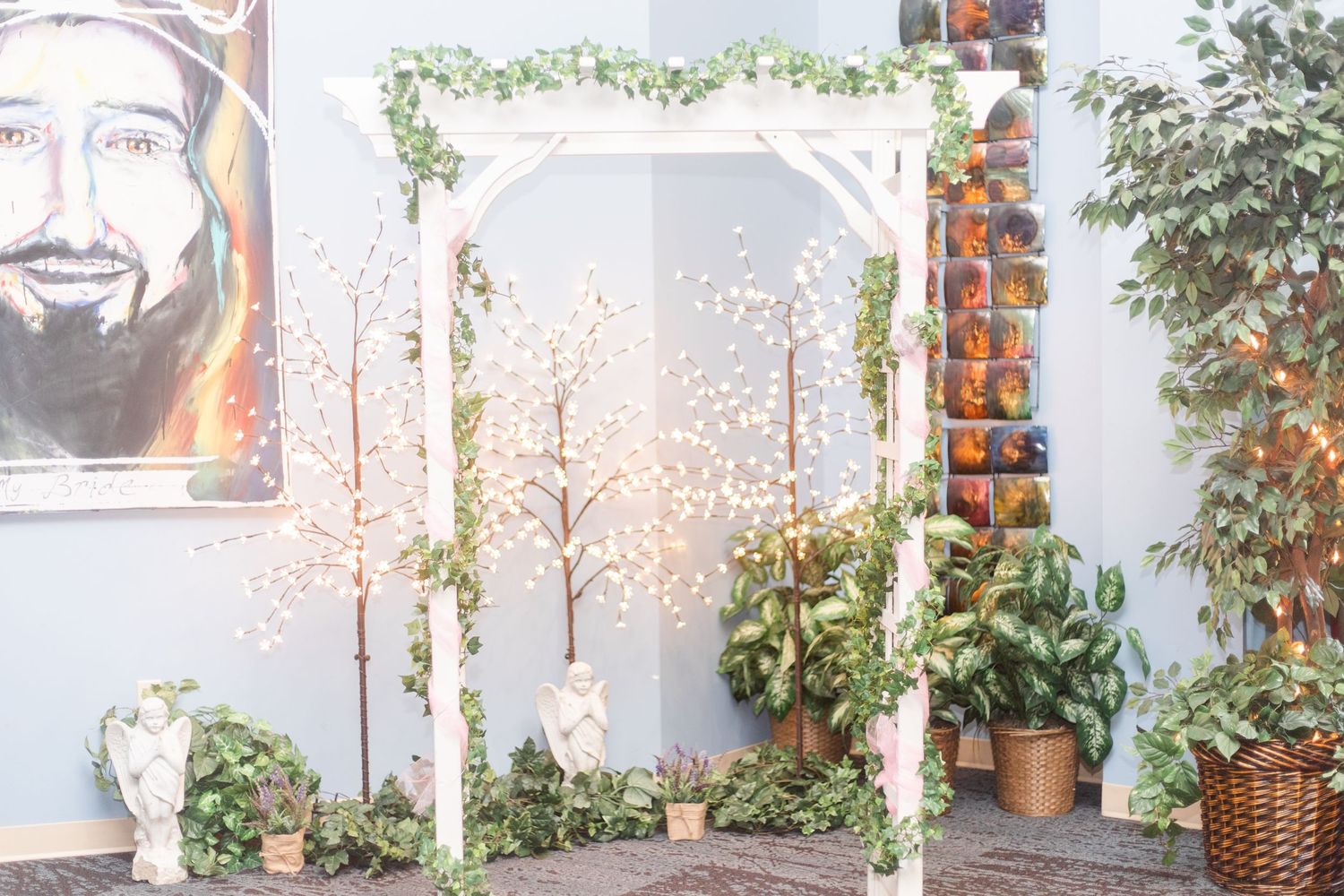 Wedding venue decorated with hanging greenery, string lights, and white fabric creating a romantic atmosphere.