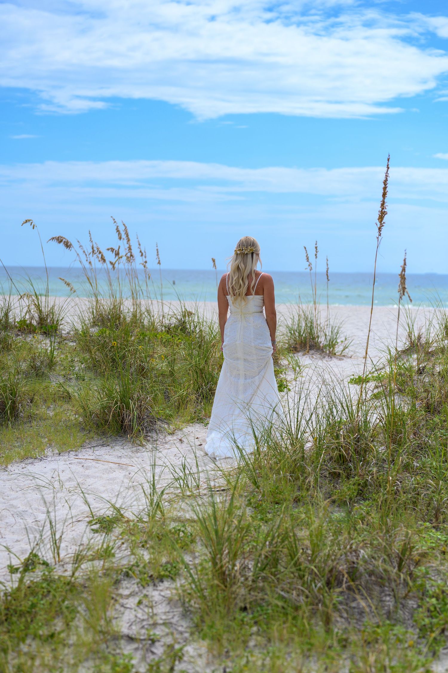 Bride walking to beach.