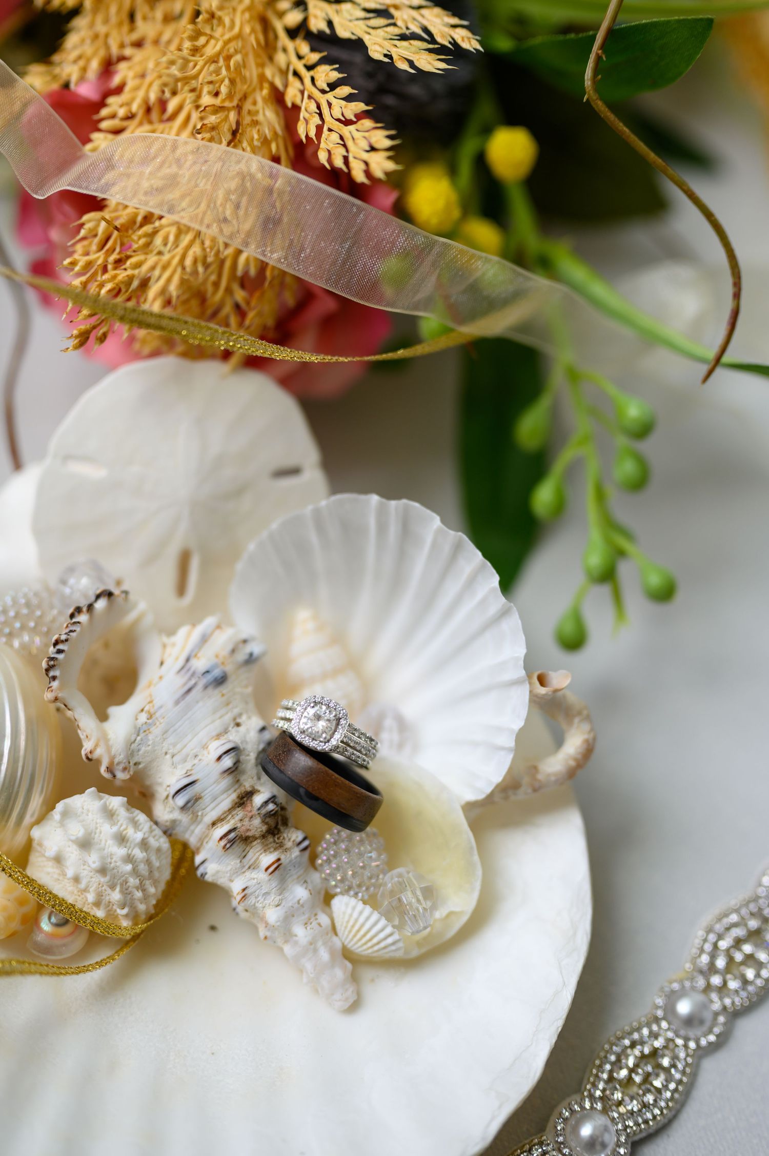 Flay lay image of wedding rings in shells.