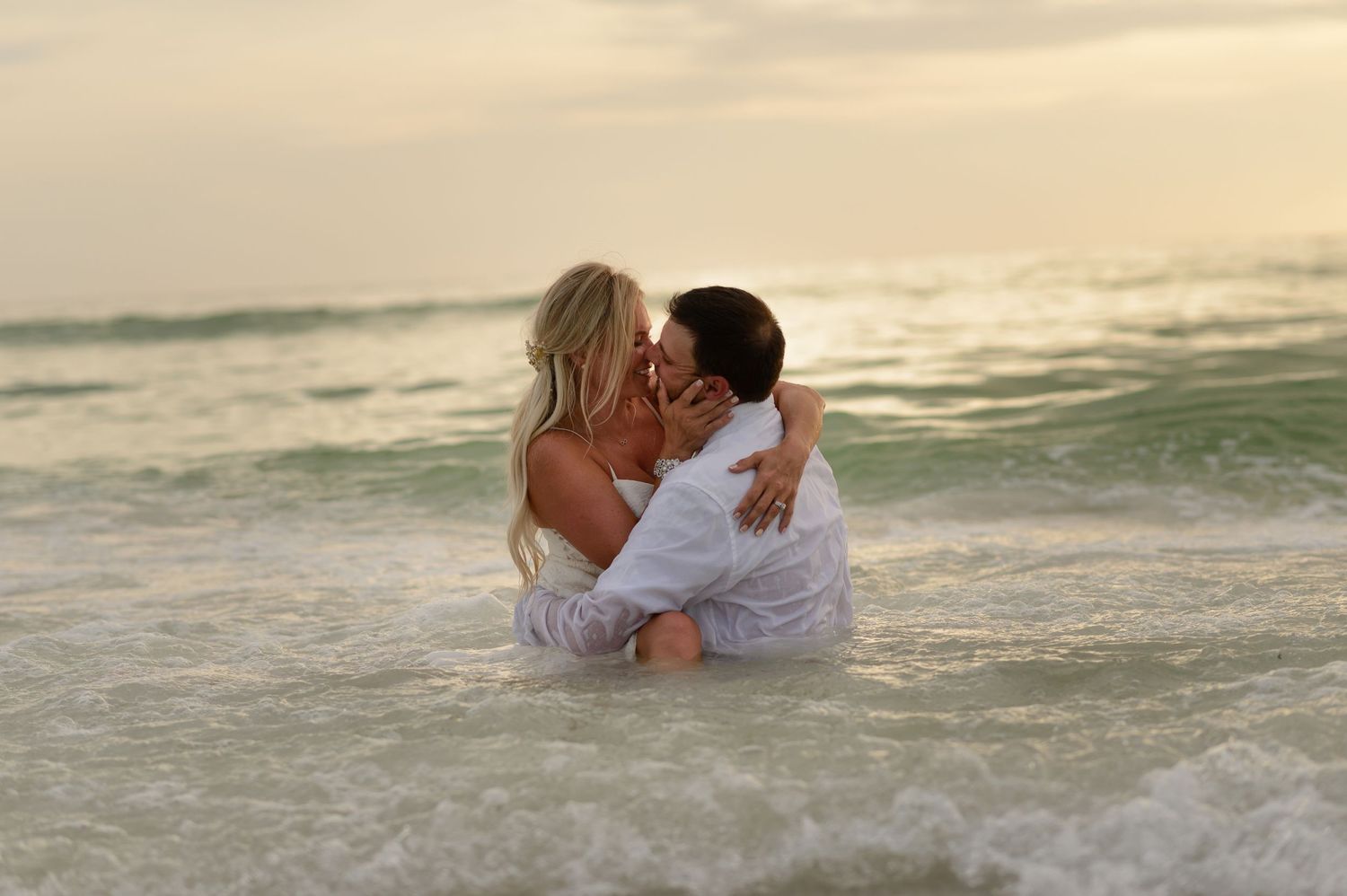 Bride and Groom kissing in the ocean.
