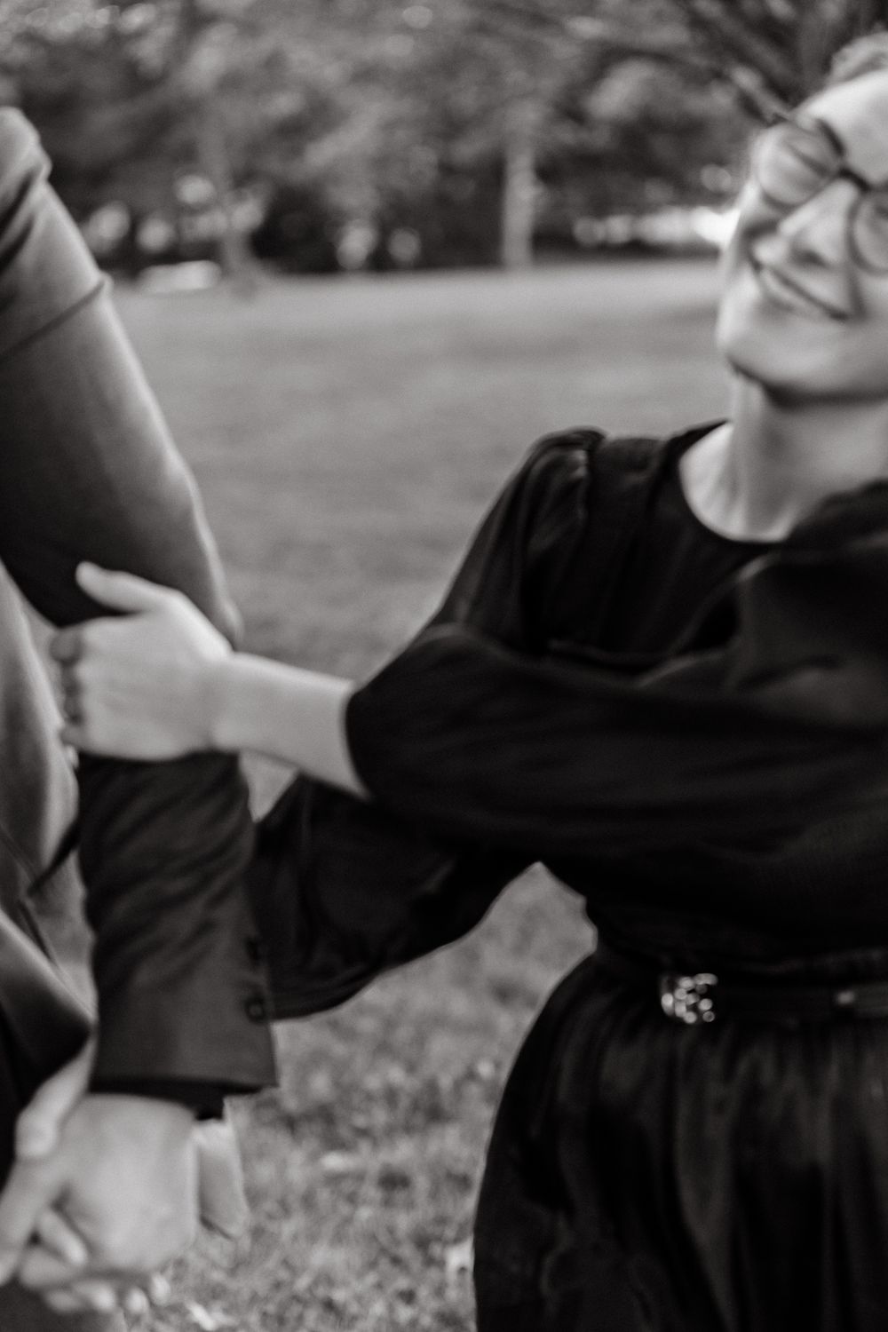 Black and white images of playful moments between two people in a park.