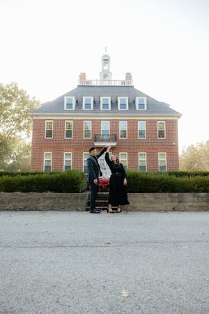 Classic brick colonial building with white trim and dormers photographed at dusk.