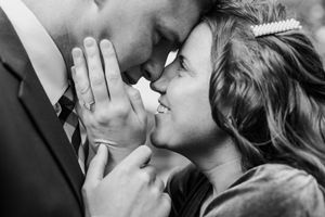 An intimate black and white close-up of a couple sharing a tender moment.