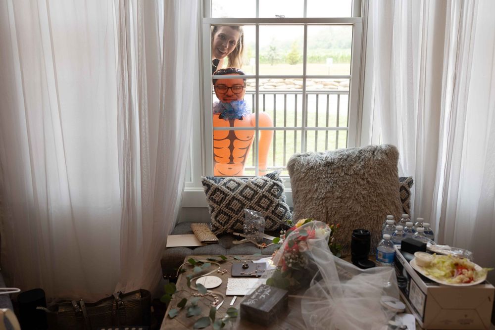 Messy room with sunlit window and curtains showing preparation space.