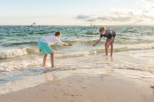 Two people splashing and playing in ocean waves at beach.