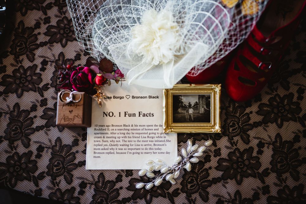 Wedding details including lace, jewelry box and framed photo on dark lace background.