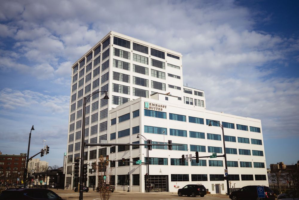 Modern white office building with geometric architecture against blue sky.