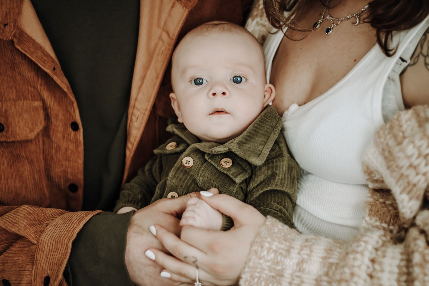 Baby wrapped in cozy blankets being held close in a warm, intimate moment.