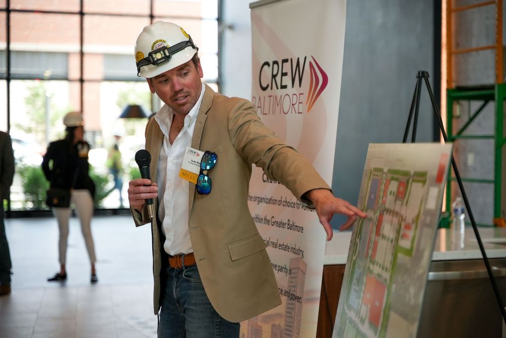 Business professional gesturing while presenting at CREW Baltimore event.