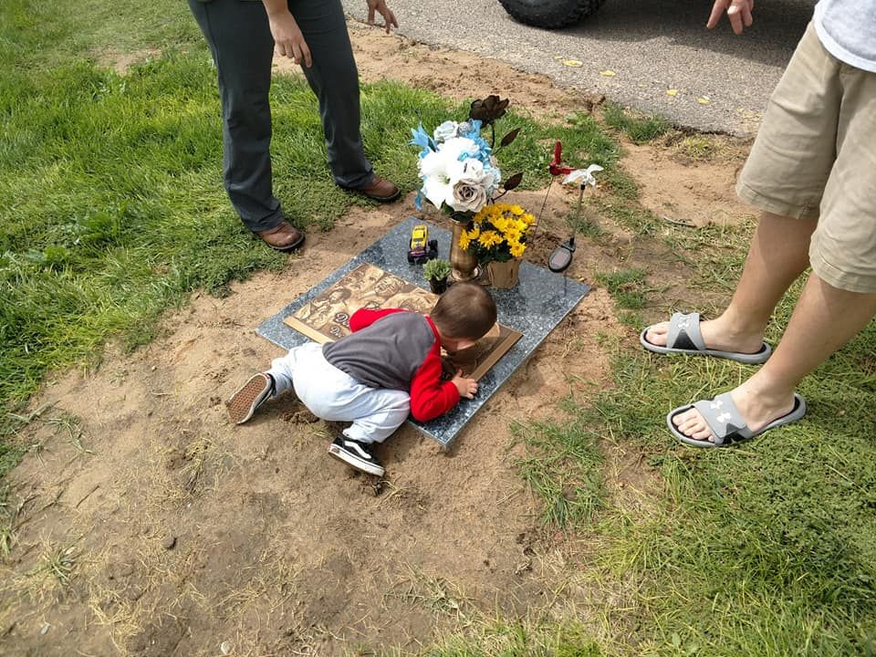 older brother kissing grave sight
