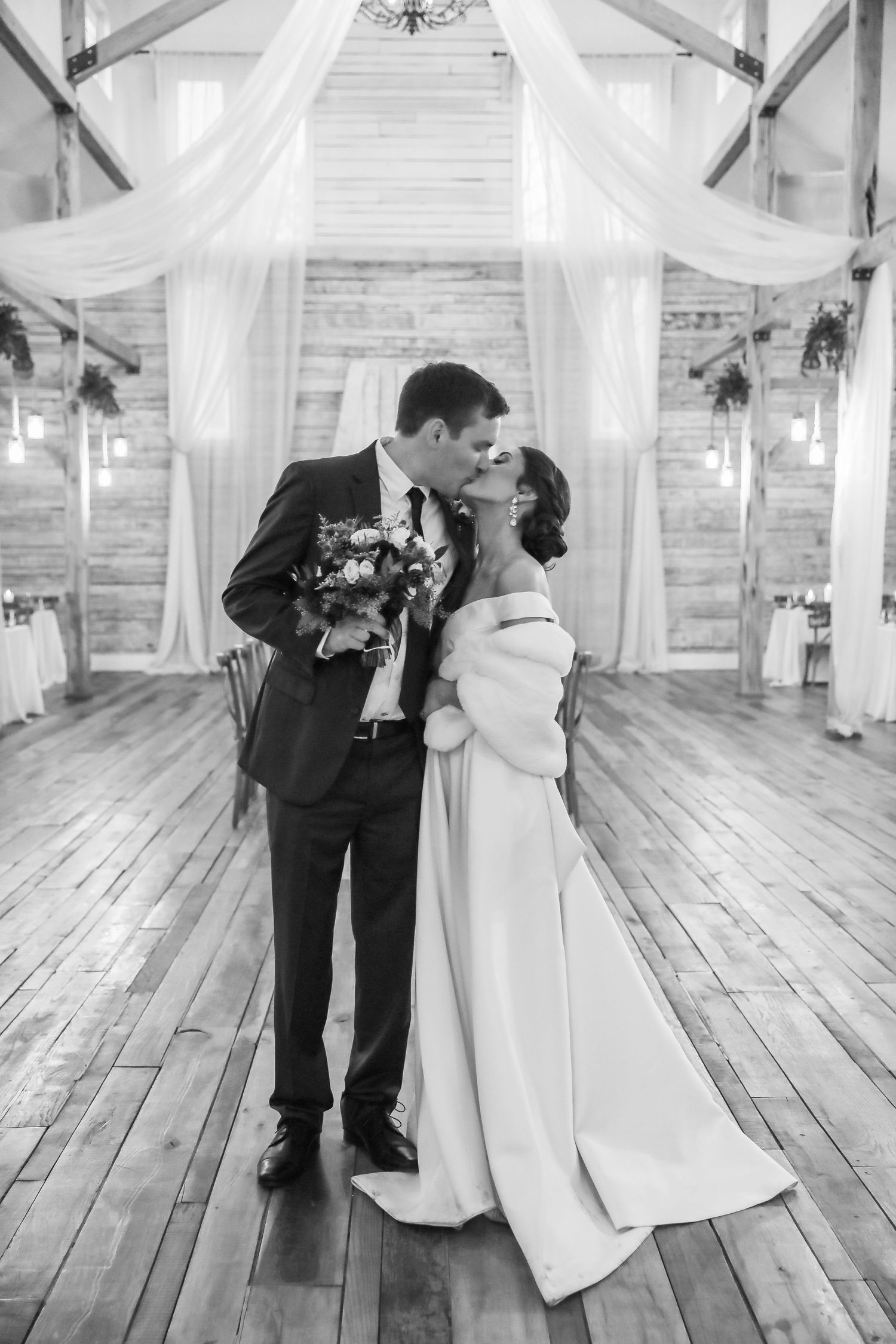 Bride and groom kissing inside Ramble Creek Vineyard at their December wedding