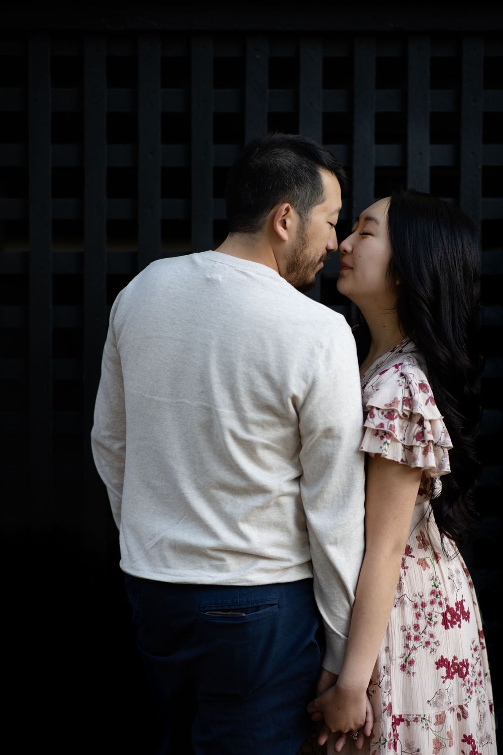 An intimate moment shared between a couple against a geometric black background.