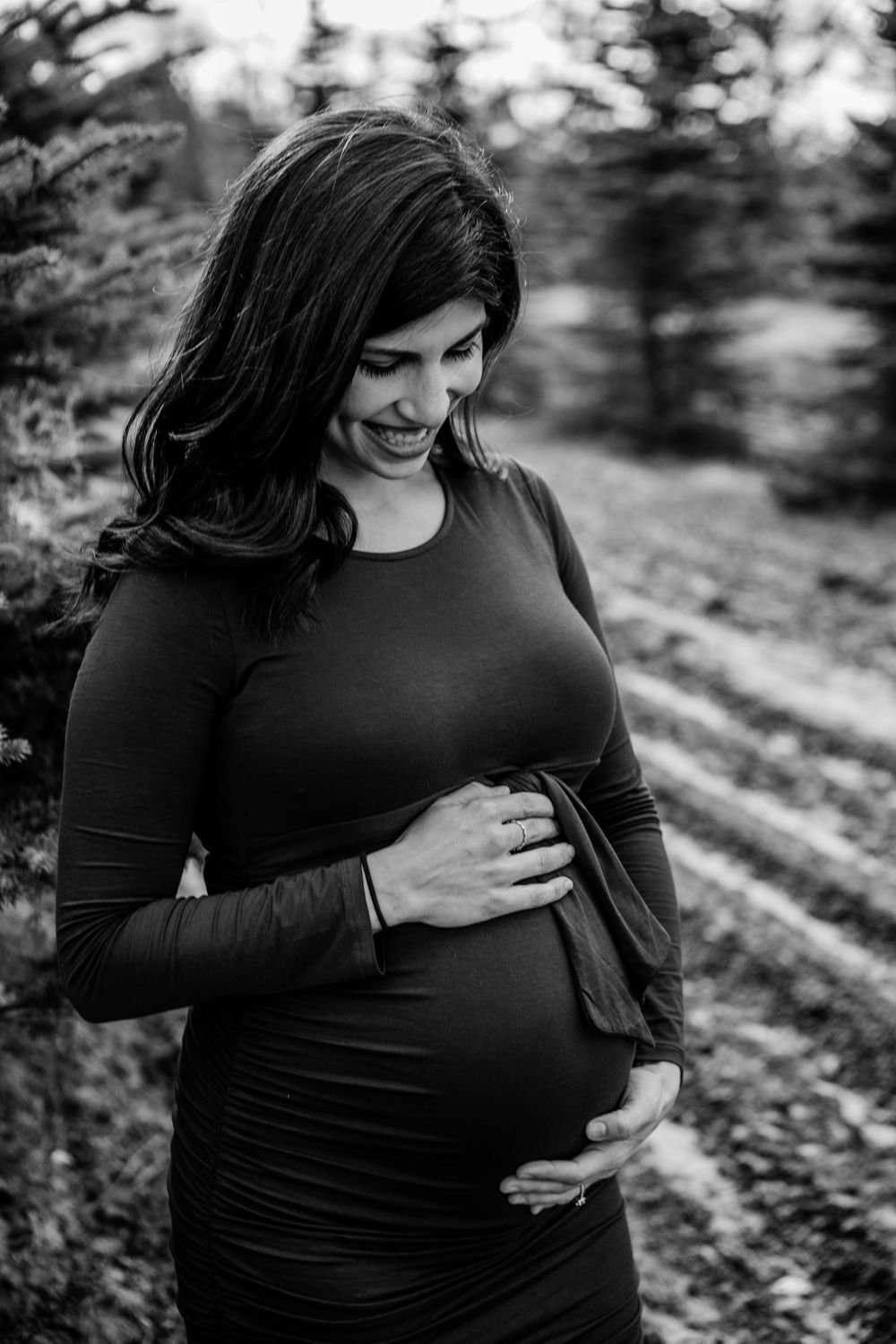 Black and white maternity photos showing tender moments in outdoor setting.