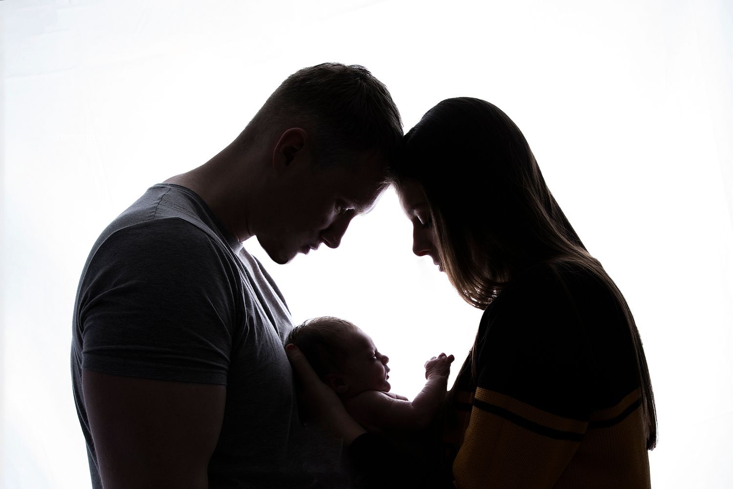 Black & White Back lit silhouette Mum & Dad gazing down at their little baby