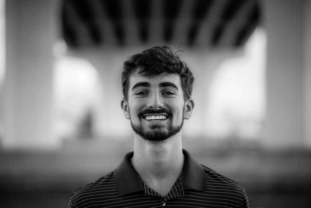 Black and white portrait with sunburst lighting effect in background.