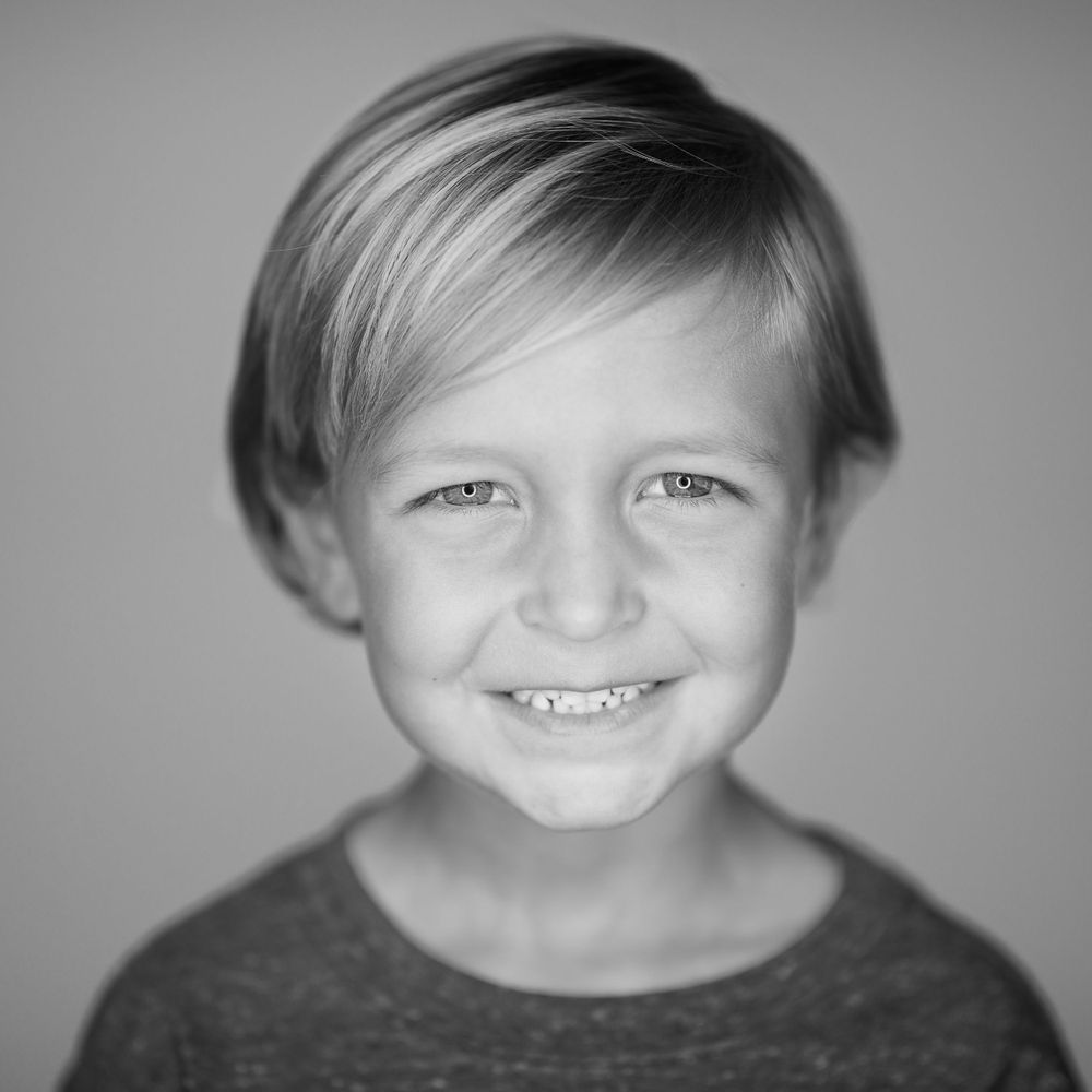 Black and white portrait with soft lighting against a neutral background.
