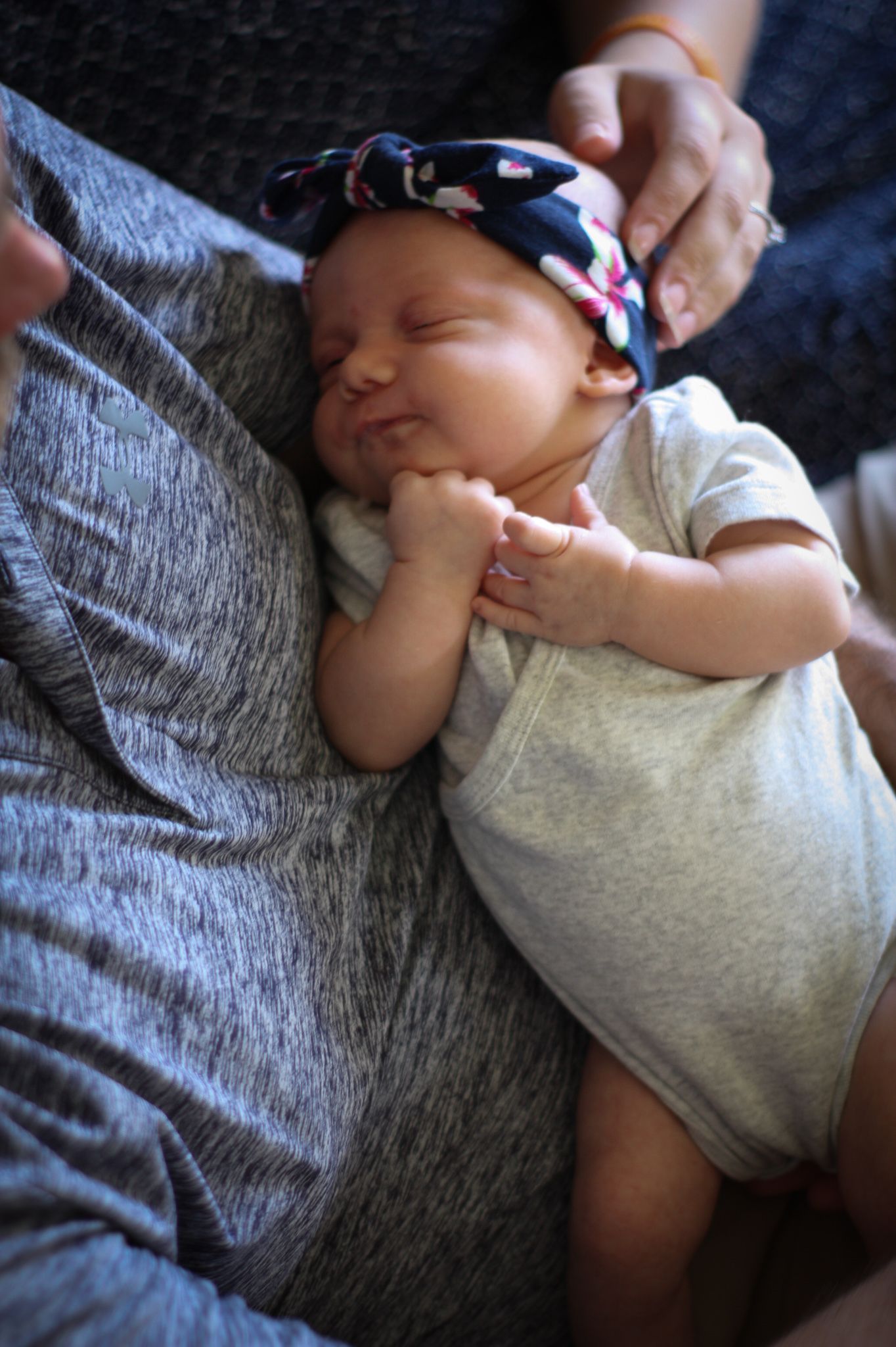 Newborn baby girl snuggling her daddy during their in-home newborn session in Sioux City, IA.