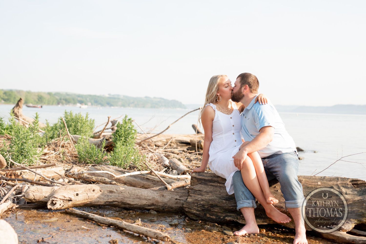 A tender moment shared while sitting on driftwood by the shoreline.