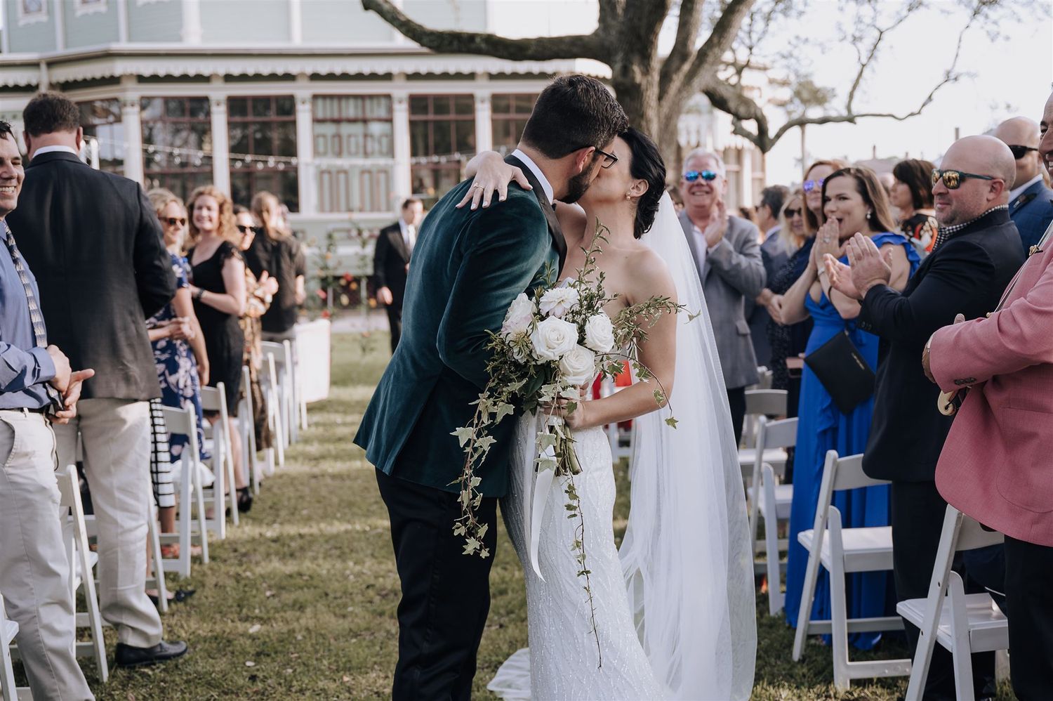 Joyful wedding ceremony exit with guests lining the aisle at an elegant outdoor venue.