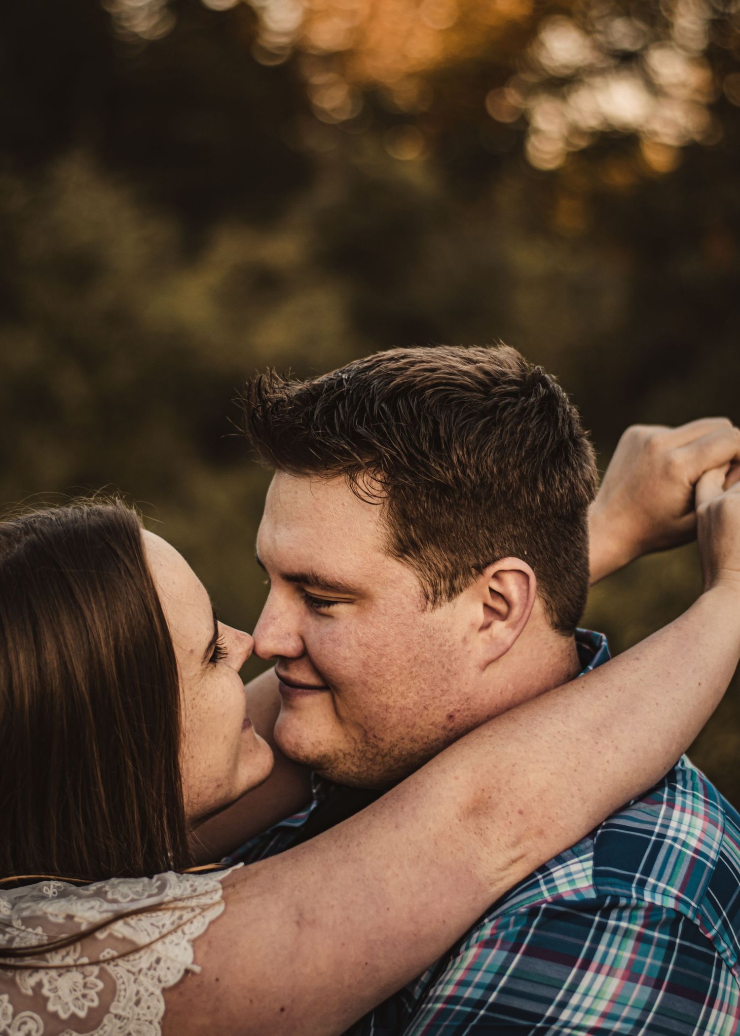 Intimate close-up of a couple embracing on a path at sunset.