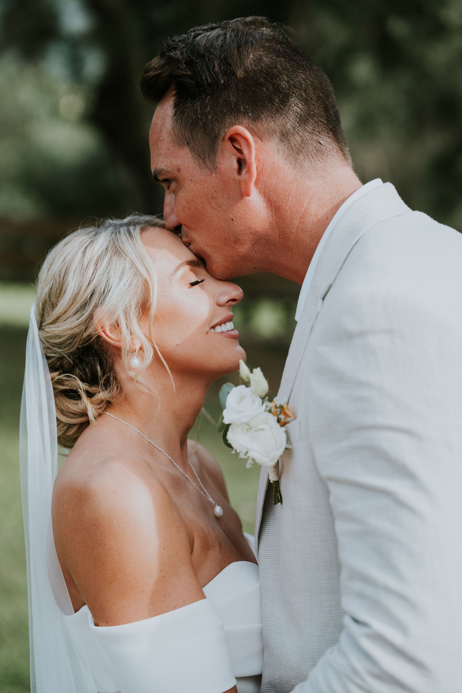 An intimate moment between newlyweds during their outdoor wedding portraits.