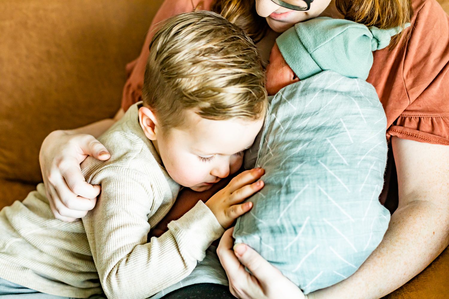 Mom and one of her sons snuggle the newest baby boy in Monument, Colorado.
