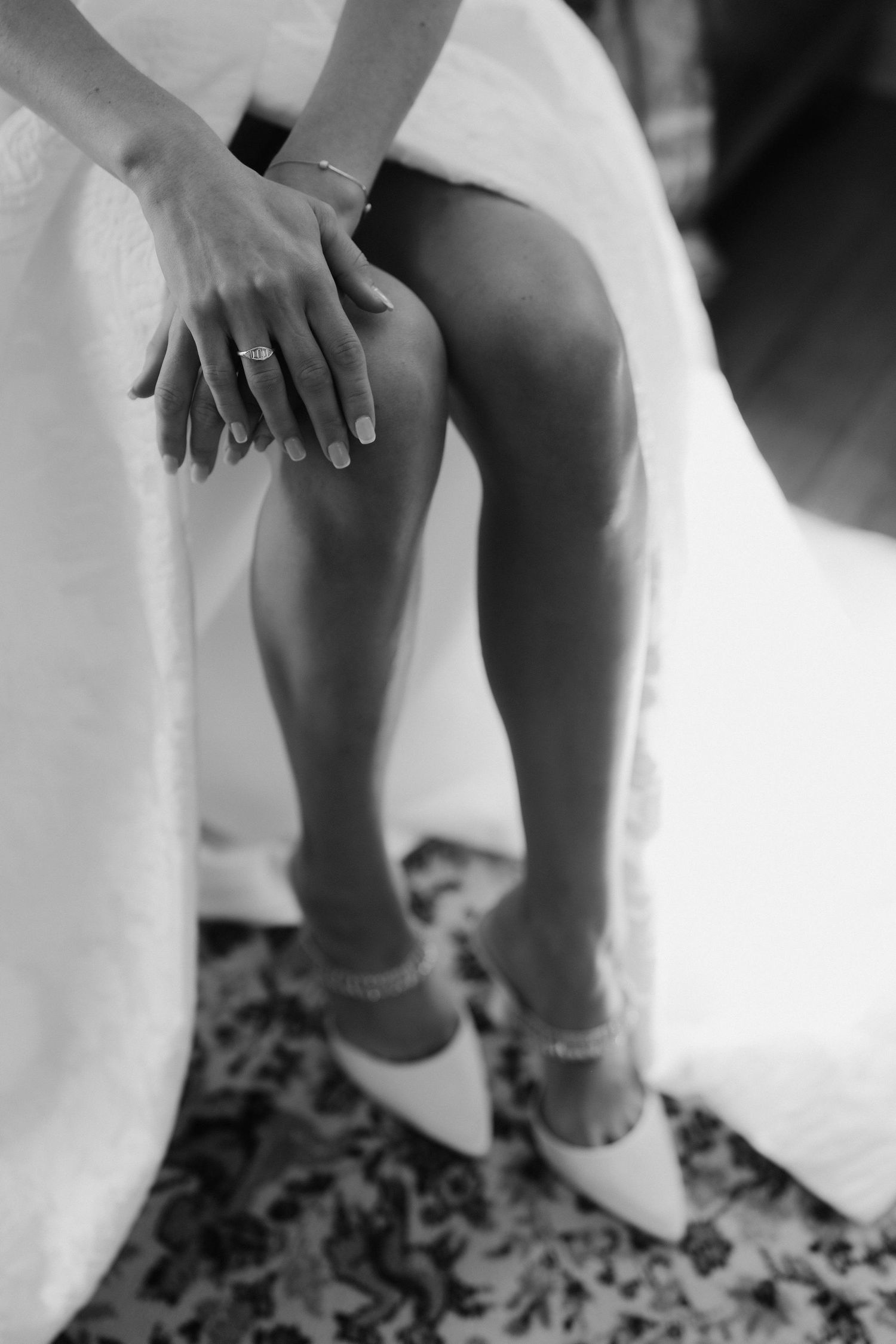 close up of brides rings and hands resting on her knee