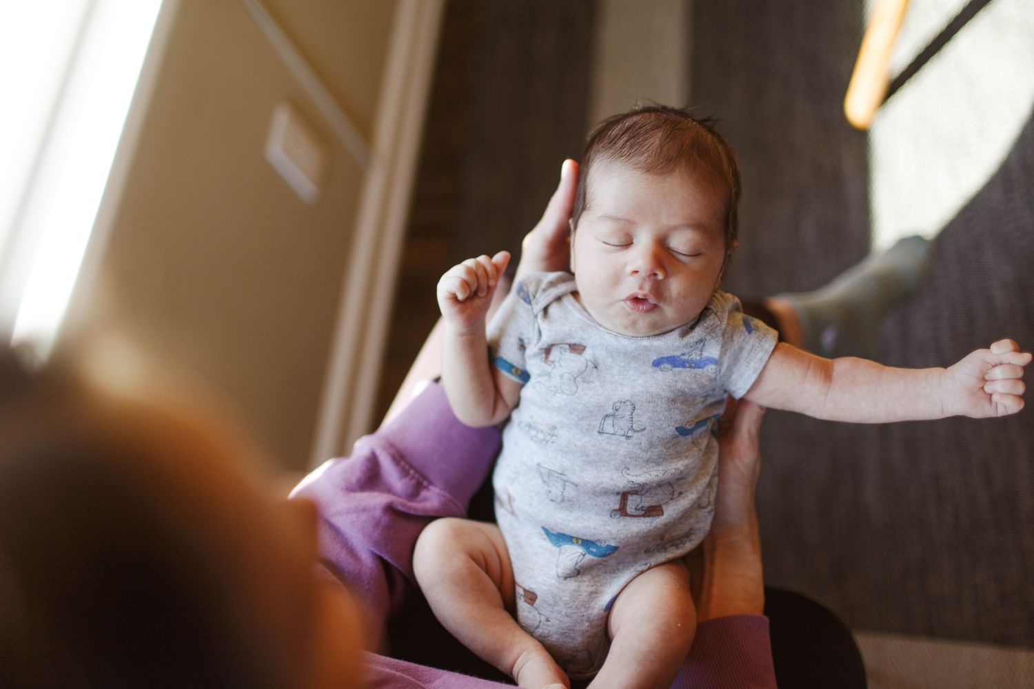 a mother holds her baby at their in home newborn session in Everett Washington