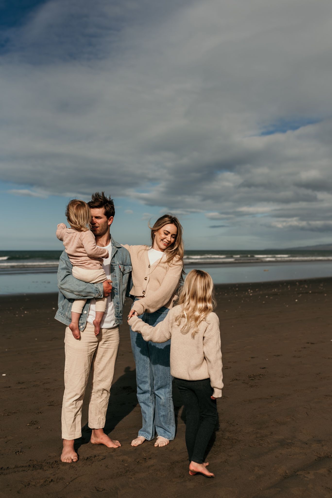 Family enjoying time together on a cloudy beach.