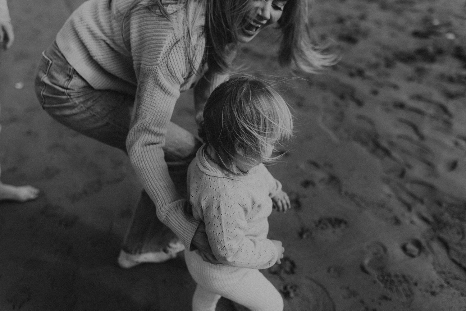 Black and white capture of loving interaction at the beach's edge.