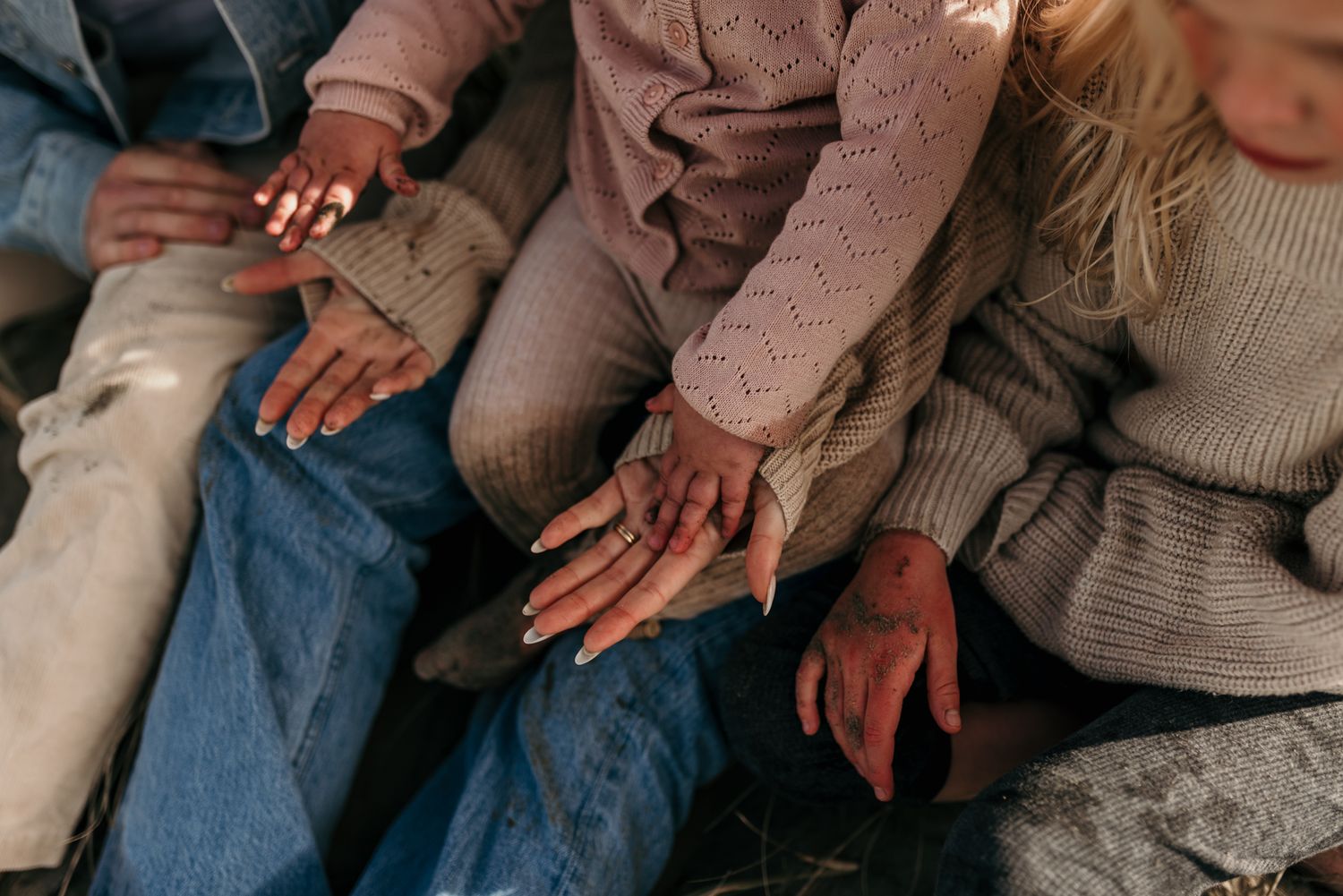 Close-up of hands resting on denim-clad legs.