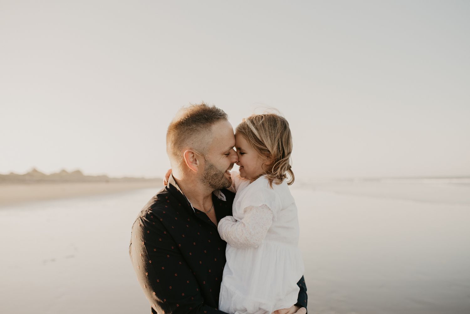 An intimate moment captured during a sunset beach photoshoot.