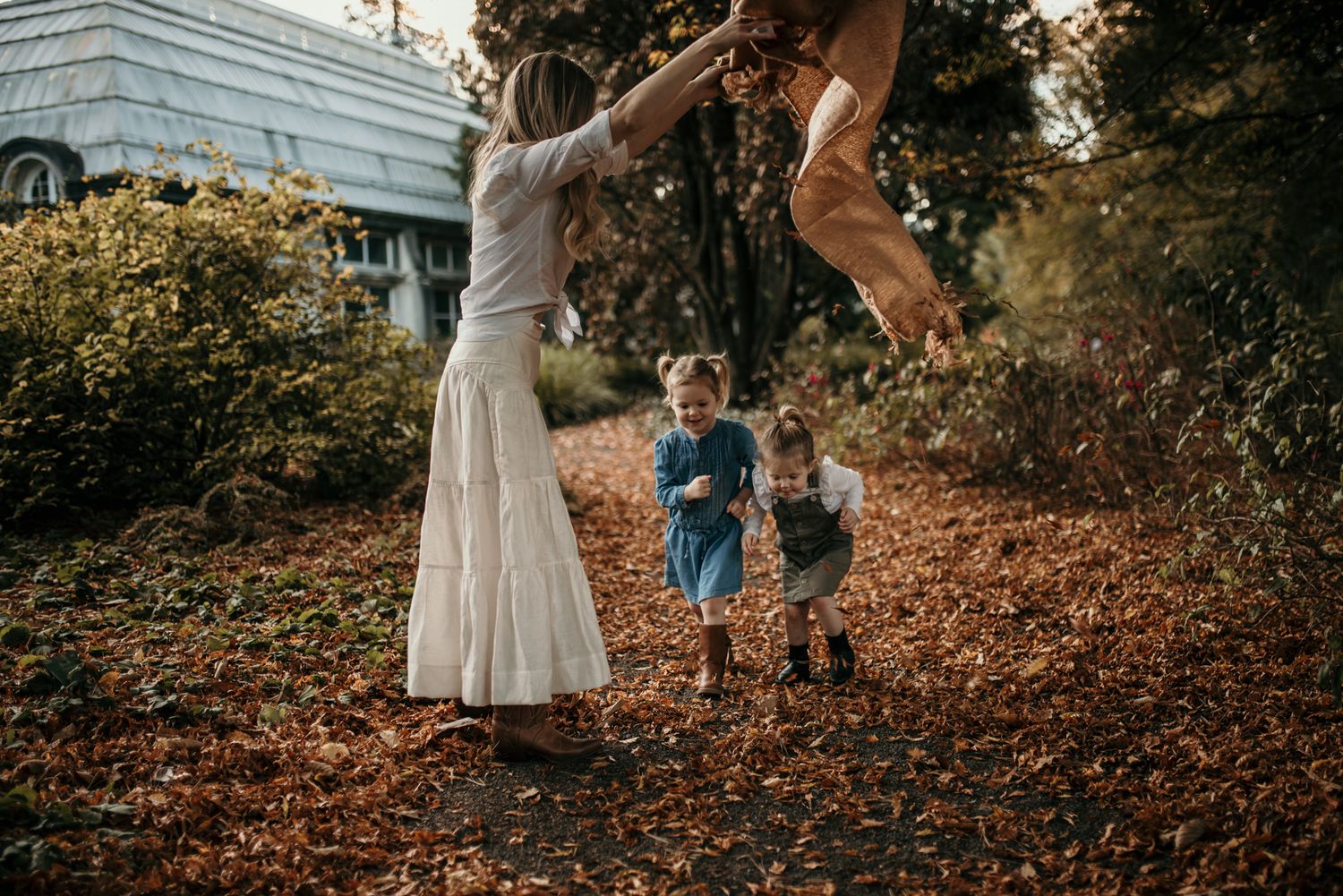 Playful autumn scene with people jumping and playing in fallen leaves.