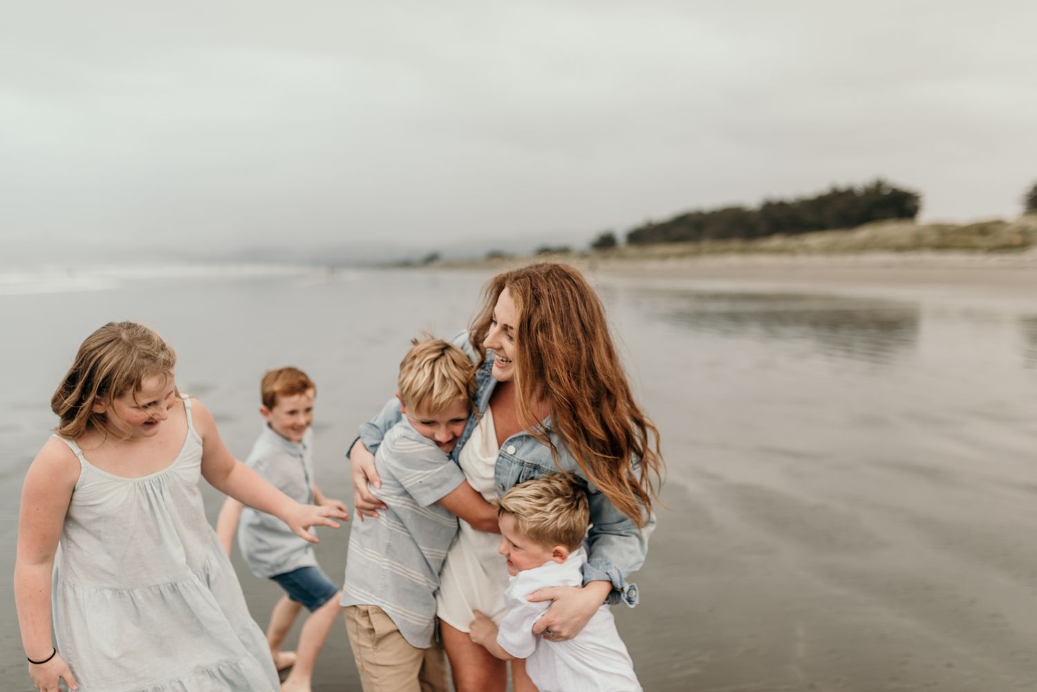 A loving group enjoying quality time together on a peaceful beach with waves rolling in.