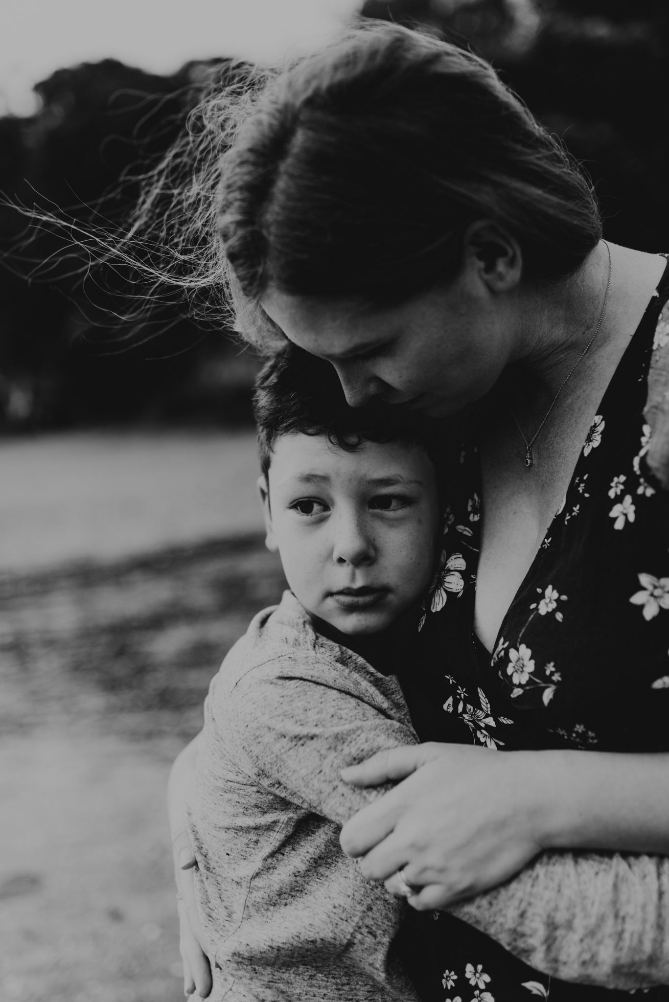 Black and white intimate portrait showing tender embrace on beach.