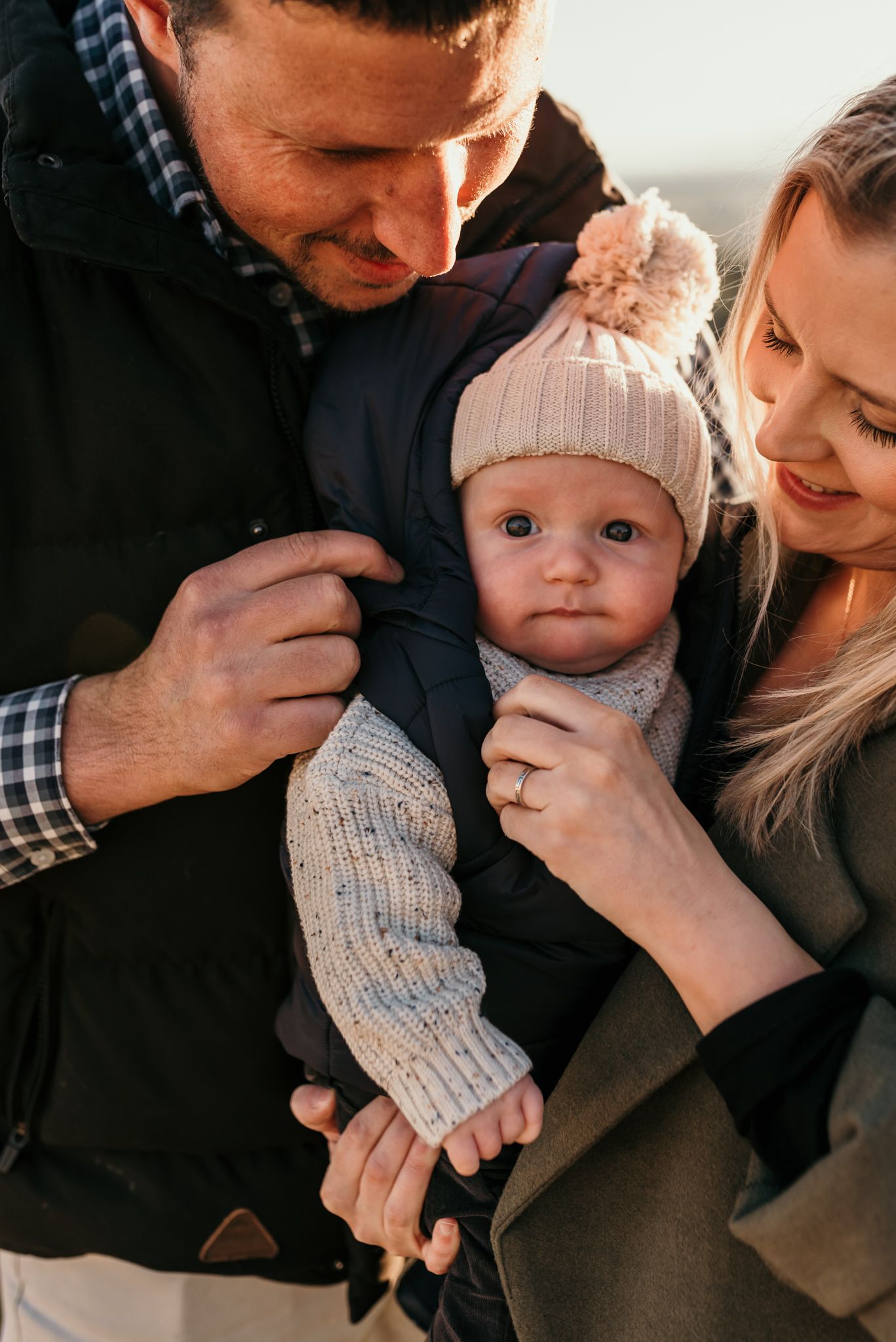 Family shares an intimate moment together while dressed in warm winter clothing.