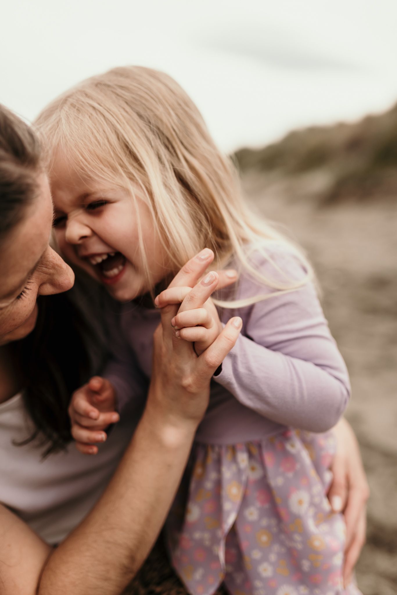 A candid moment of shared laughter and joy captured among the dunes.