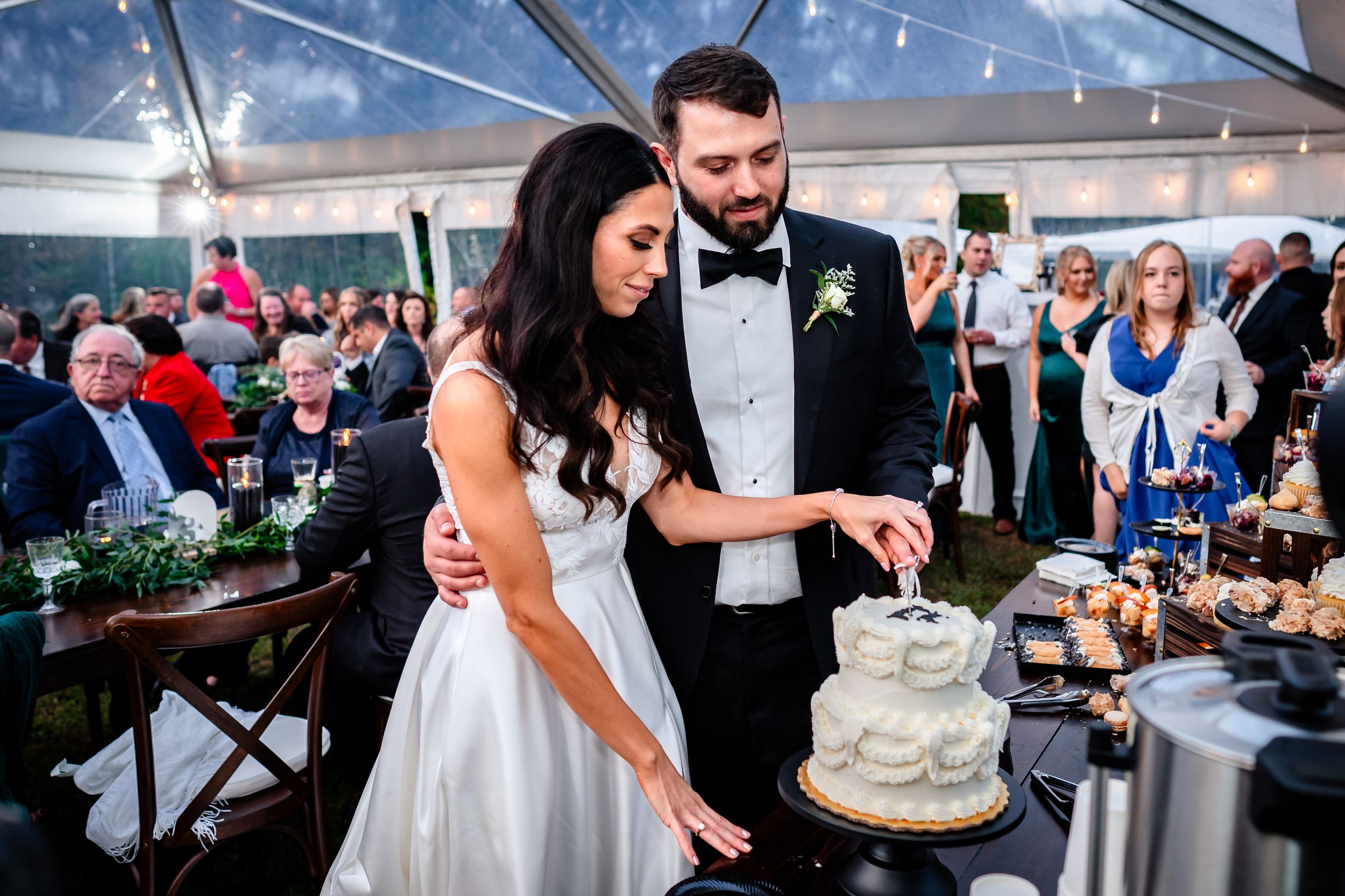 Wedding reception moments captured under clear tent with guests enjoying cake and dancing.